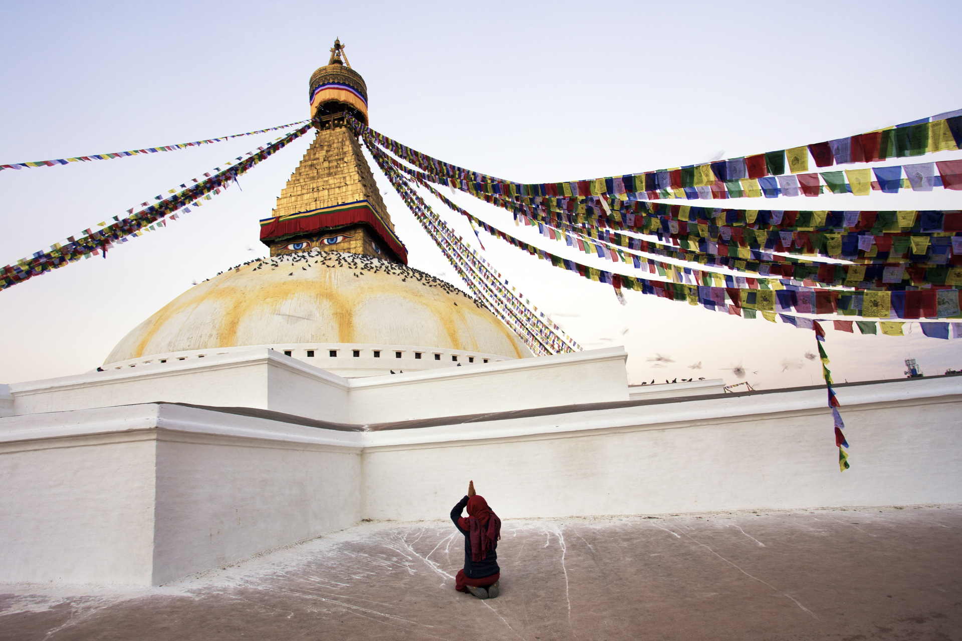 woman praying in boudhanath stupa - image taken during a nepal photo tour