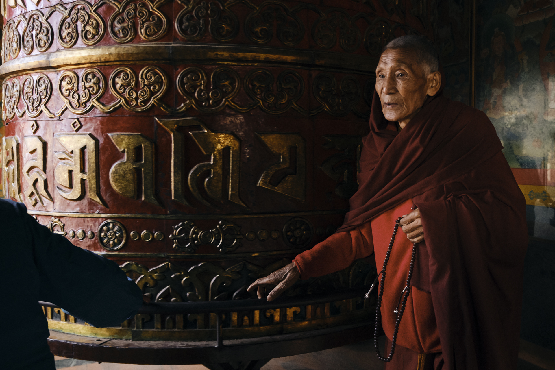 buddhist monk turning a prayer wheel in boudhanath