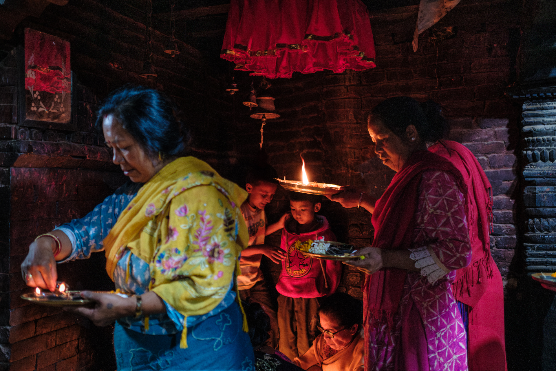 A nepali family is making a ritual with candles and tikka powder, during the night of Laxmi Puja, the most scenic day of the Tihar Festival. Extract of the Nepal photo tour by Lorenz Berna
