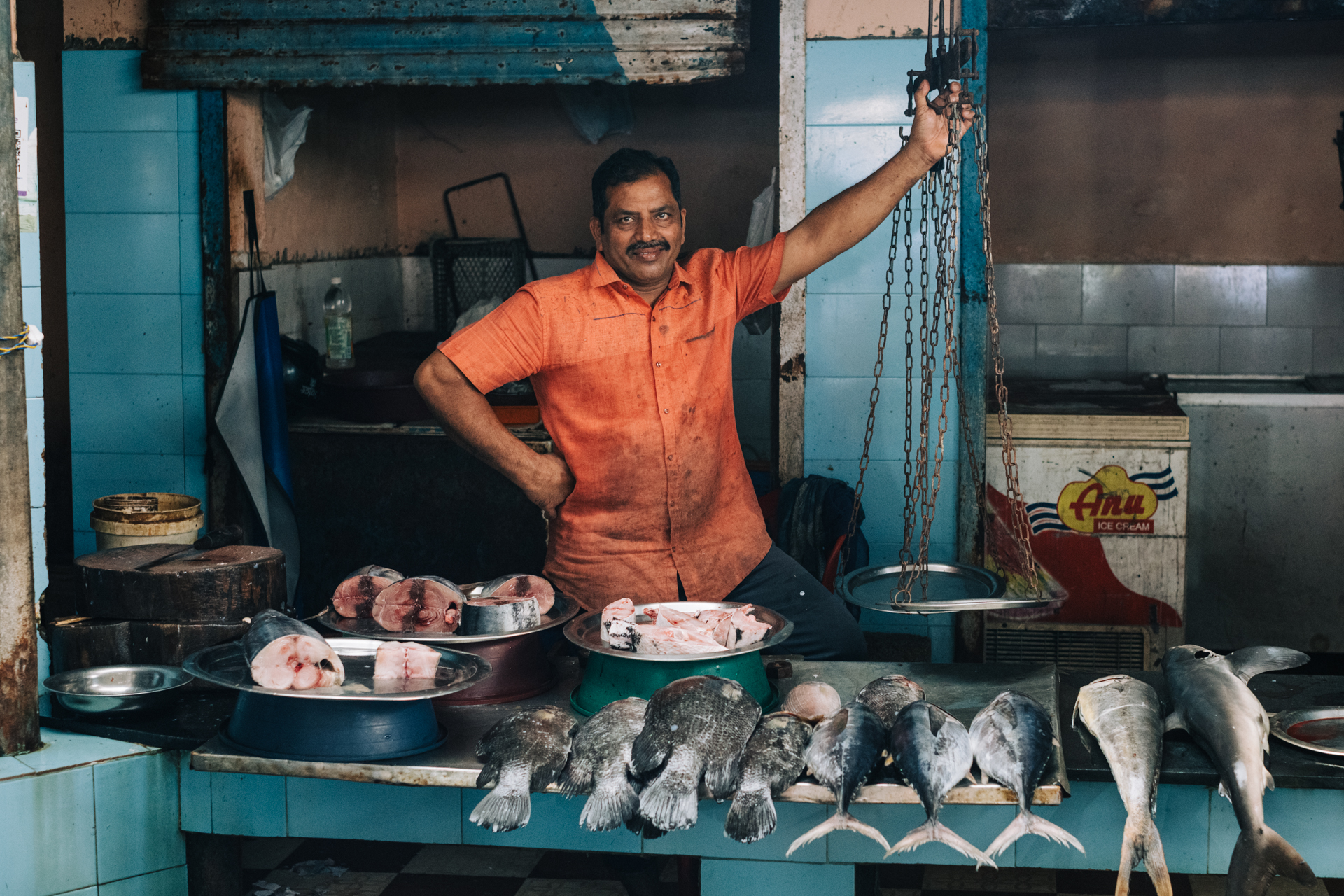 Smiling fish seller posing proudly at his stall in Fort Kochi market, Kerala