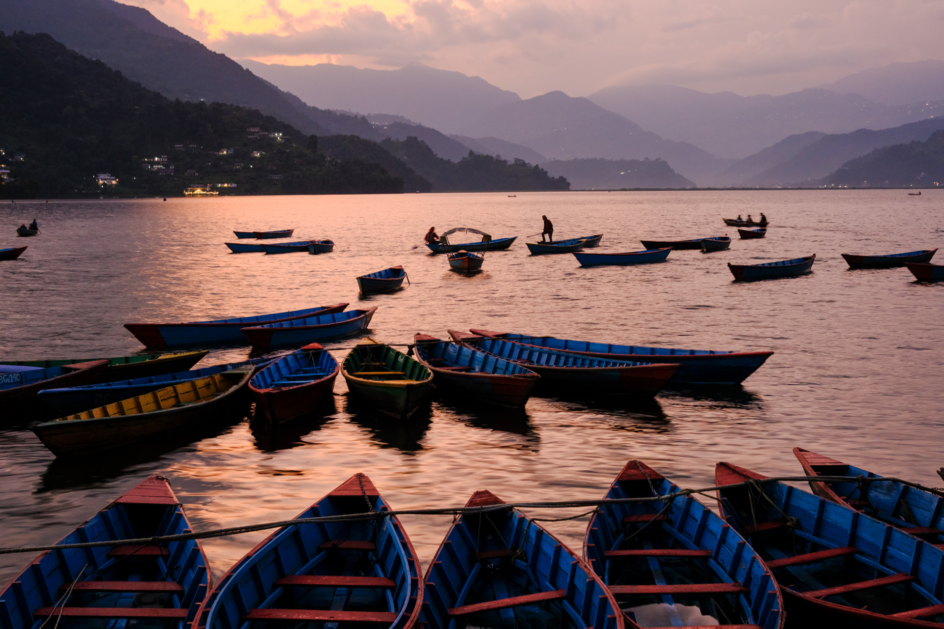 Boats and mountains at sunset, on Pokhara lake, Nepal. Photo by Lorenz Berna