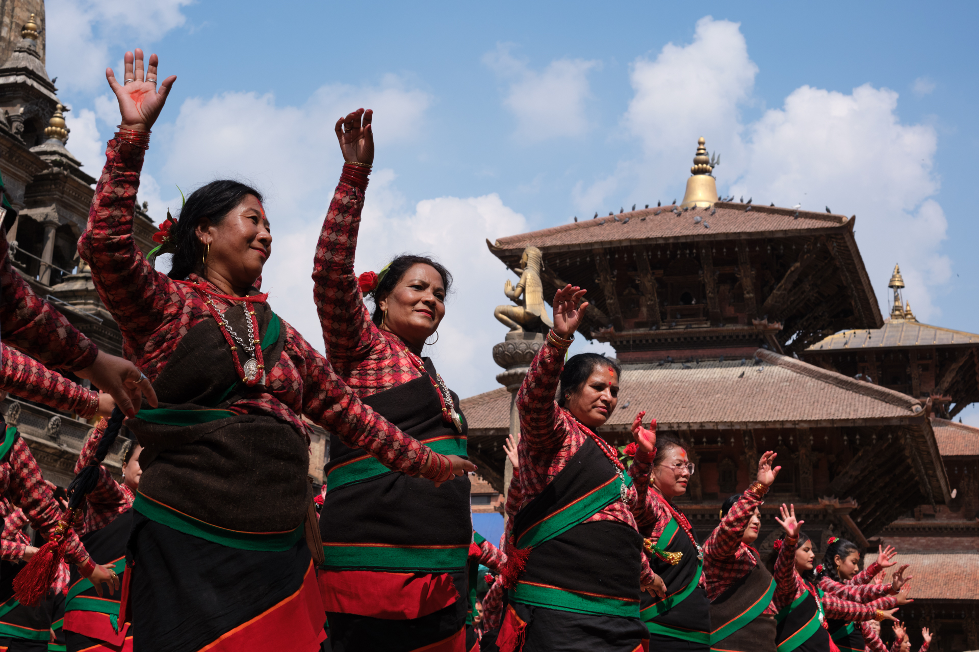 Newari women in traditional dress are dancing, lined up on the Patan Durbar Square. A Lorenz Berna's Nepal Photography