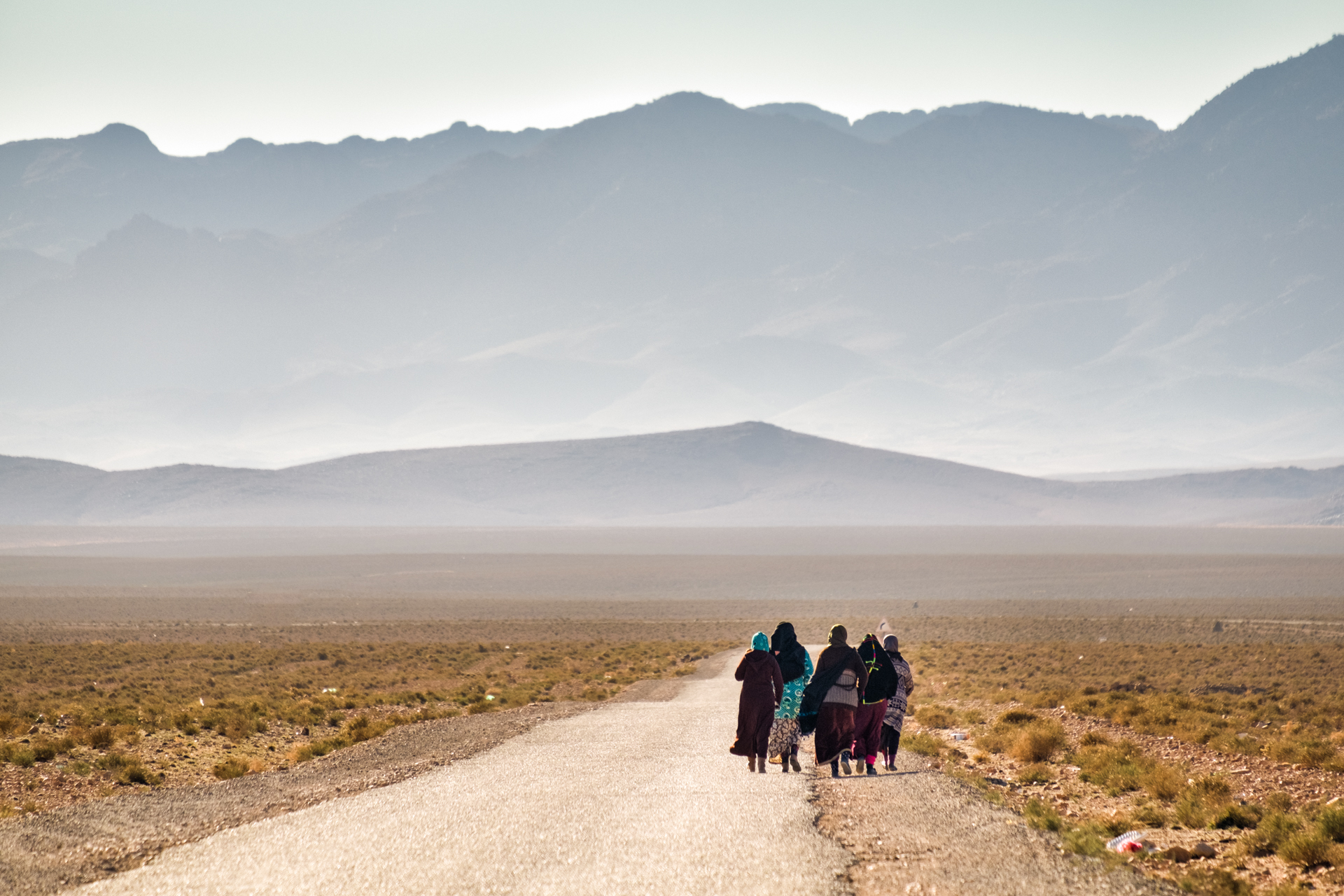 A group of women walking through a wide open landscape in morocco – a scene that rewards stillness and waiting.