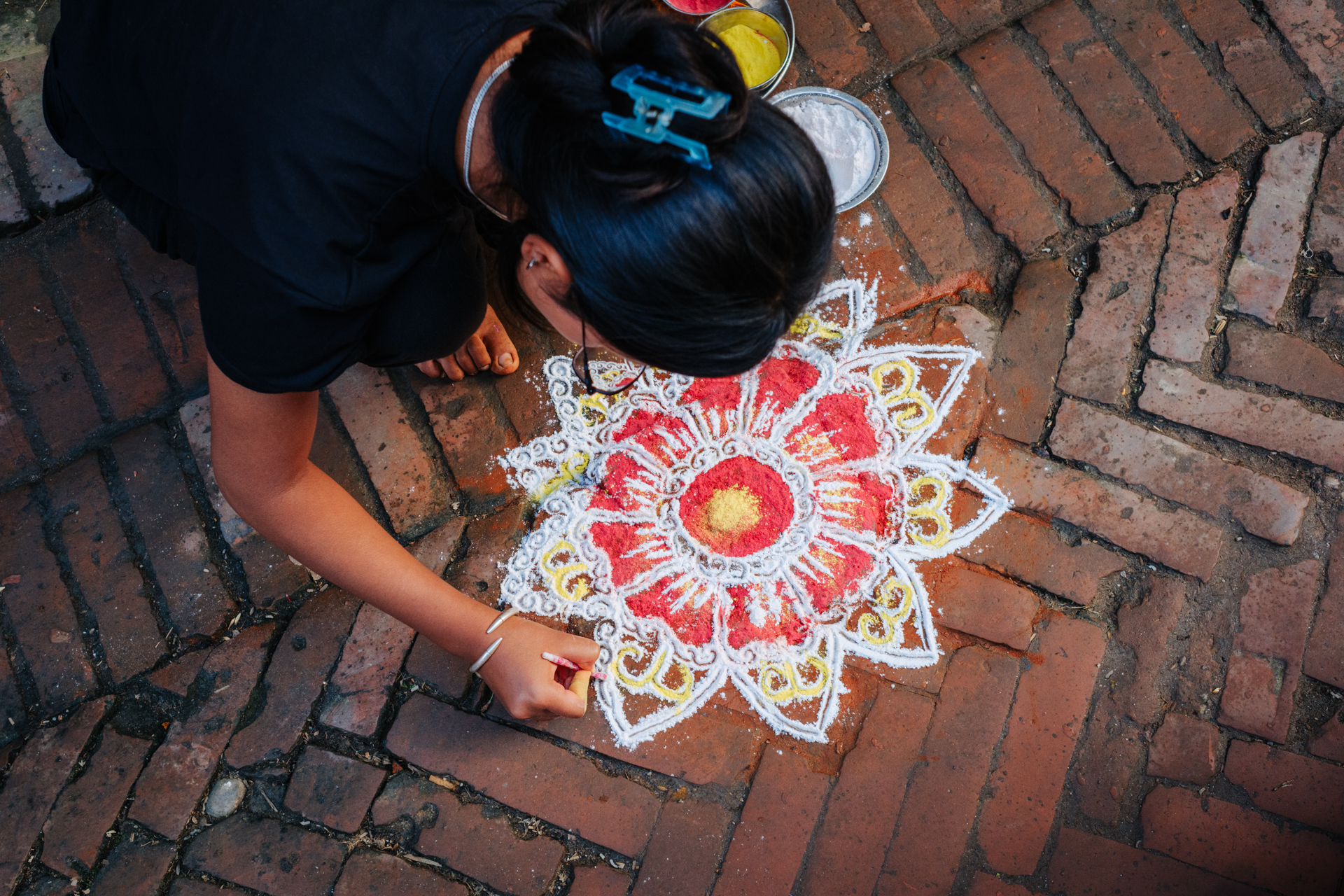 nepali girl drawng rangoli durin tihar festival