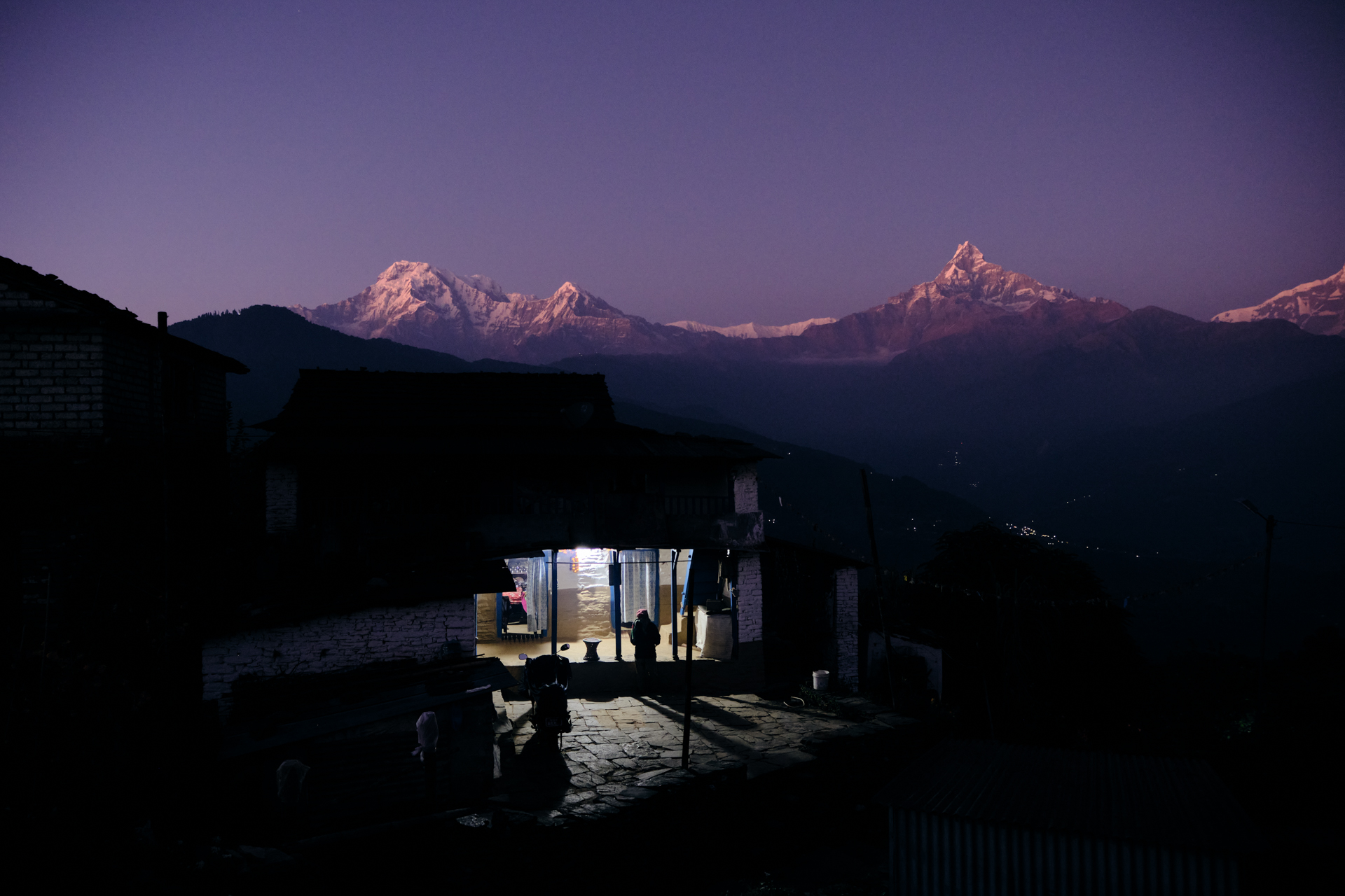 Twilight in Dhampus with Machapuchare silhouette and a lit window – atmospheric moment from Nepal photo tour