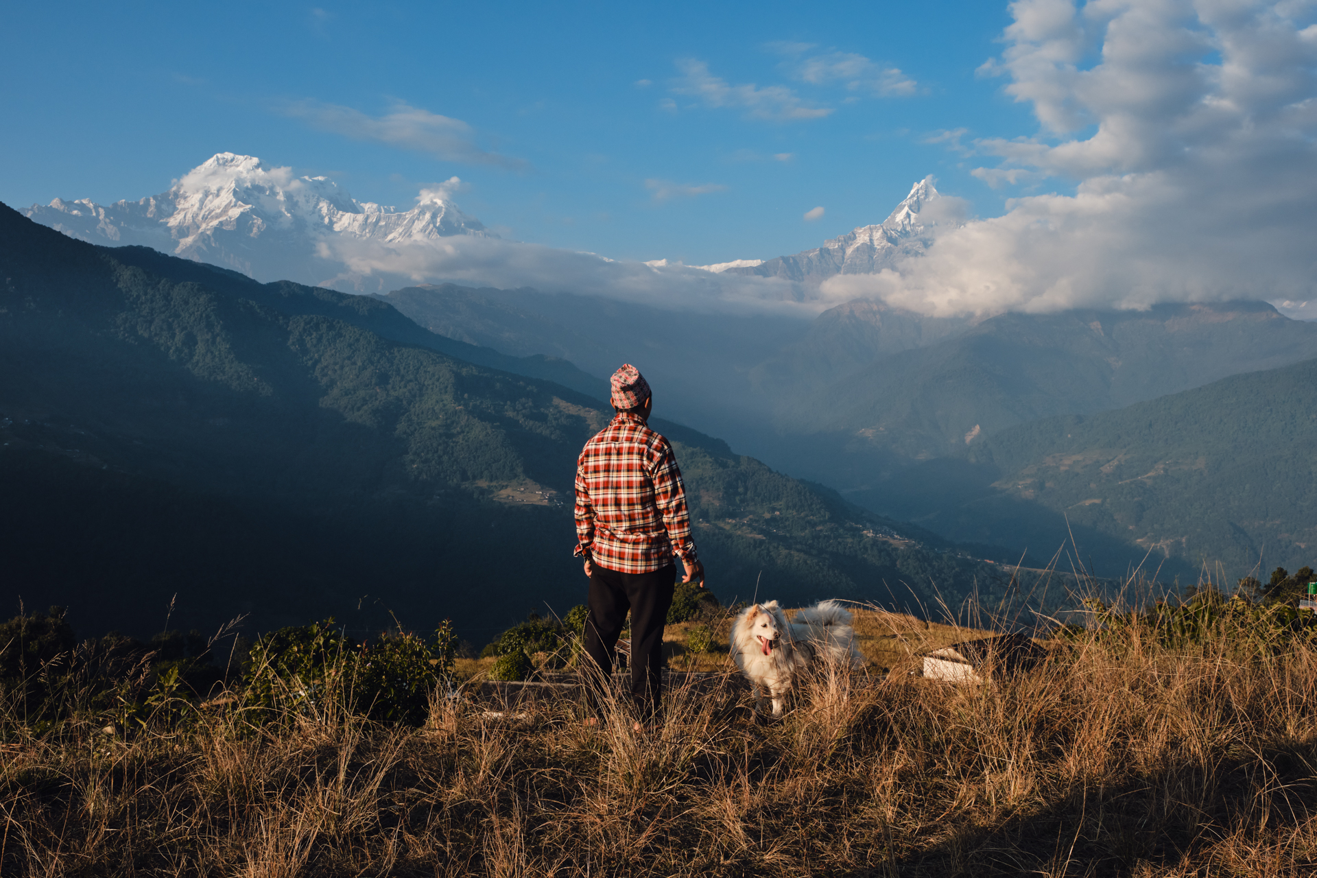 Travel photographer enjoying the Himalayan view with his dog near Dhampus